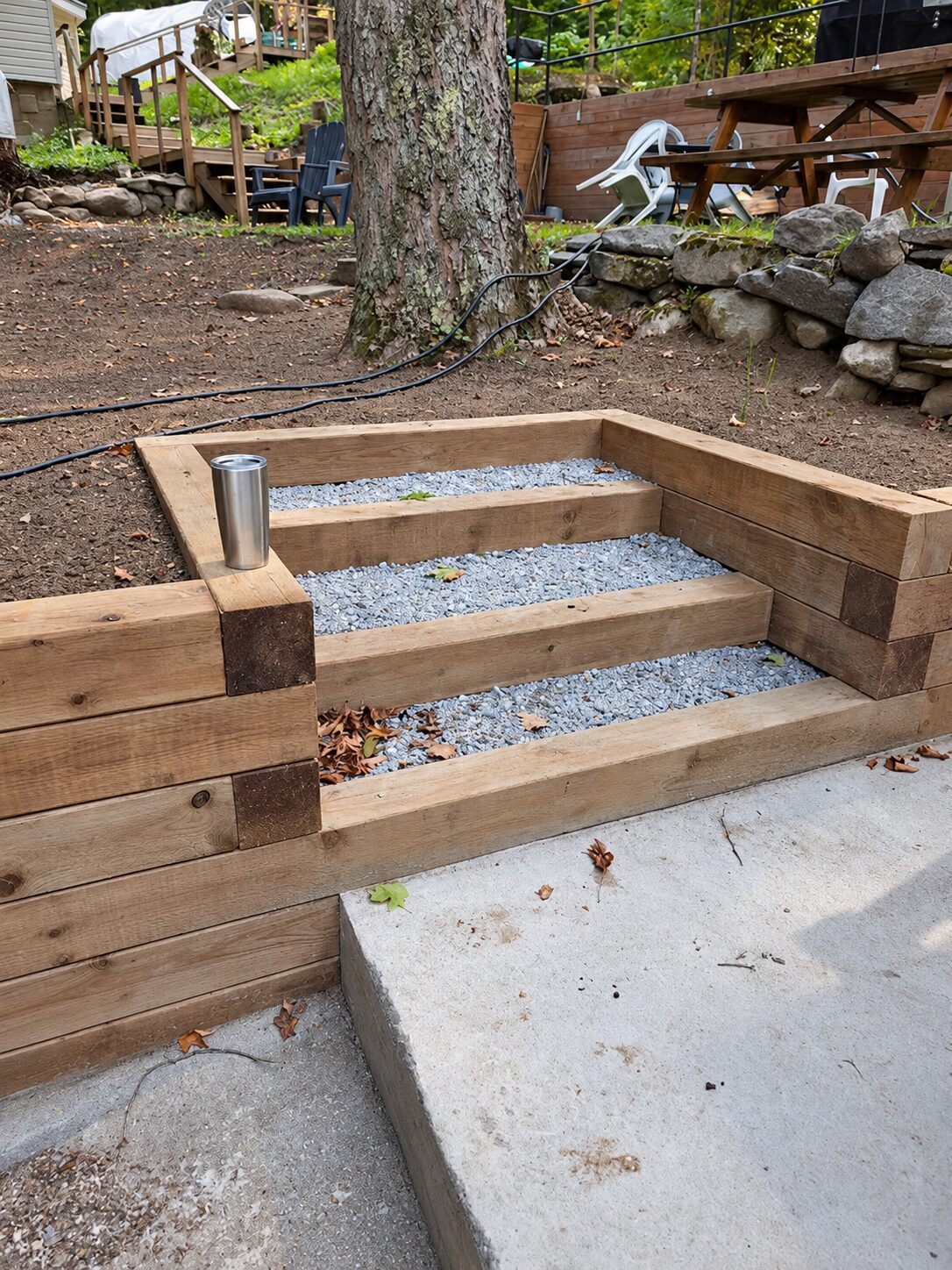 Rustic timber steps set into a sloped woodland backyard